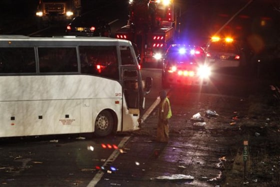 A worker is seen next to a luxury bus that crashed on Exit 9 of the southbound New Jersey Turnpike, in East Brunswick, N.J.